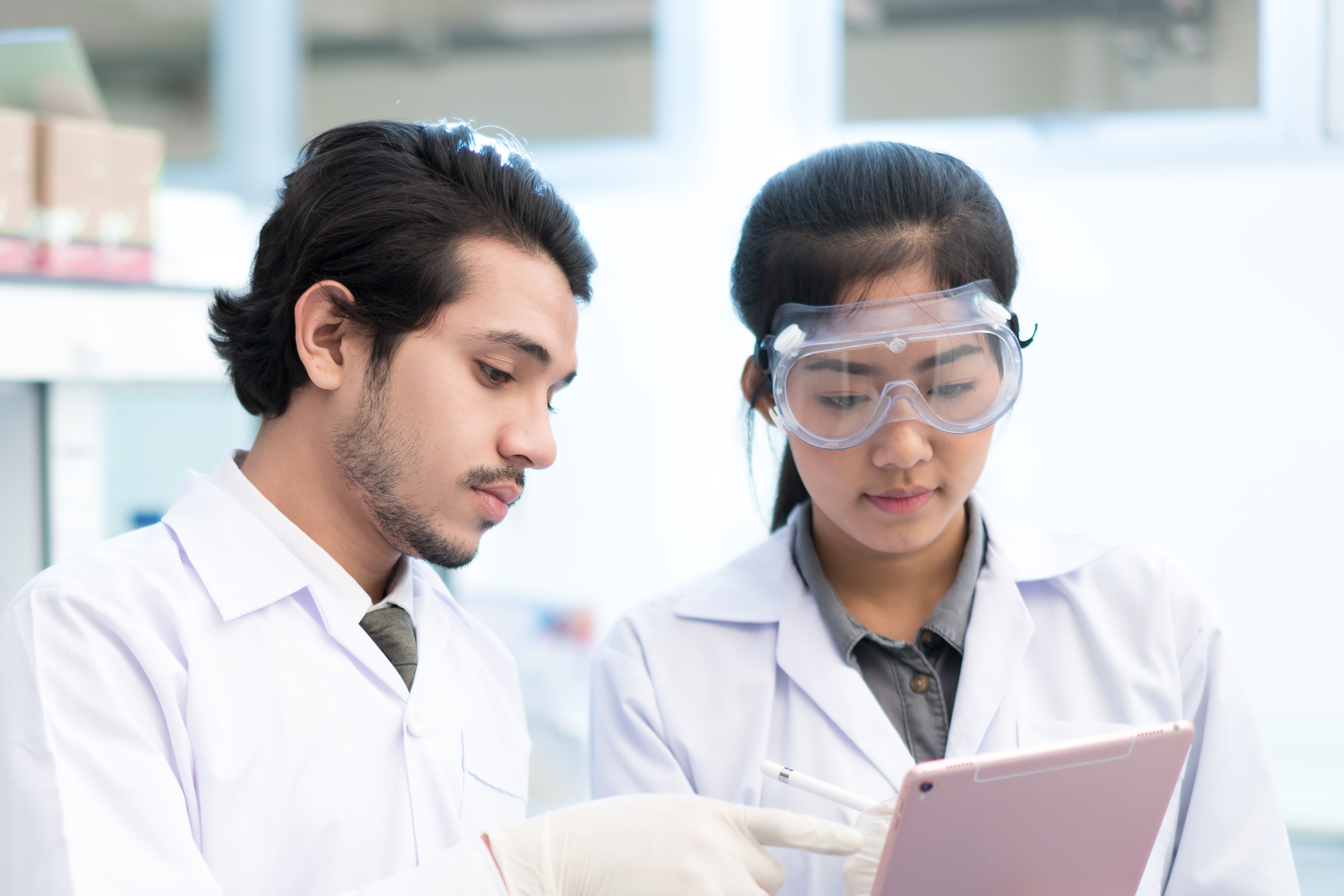 Scientists asian in the laboratory they use a tablet recording the results., Scientists asian in the laboratory they use a tablet recording t