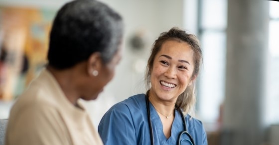 A clinician and patient smile at each other
