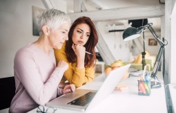Old and young ladies looking at a computer