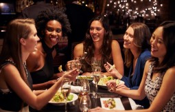 Five smiling women sitting around a party table