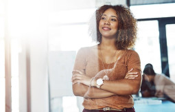 Smiling woman in a meeting room looking through the window